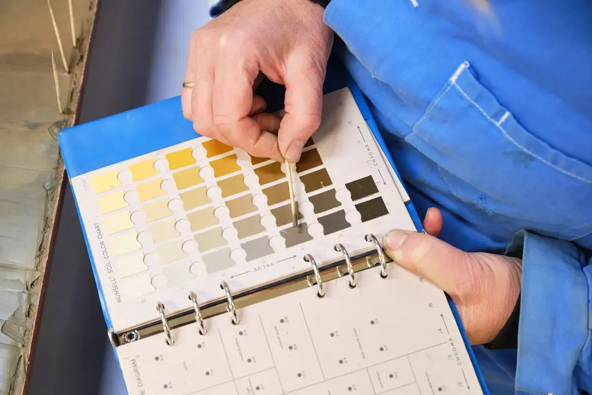 Astrid Lysa vom Geological Survey of Norway vergleicht im Labor an Bord der «Kronprins Haakon» die Probe eines Sedimentkerns mit einer Farbtafel.