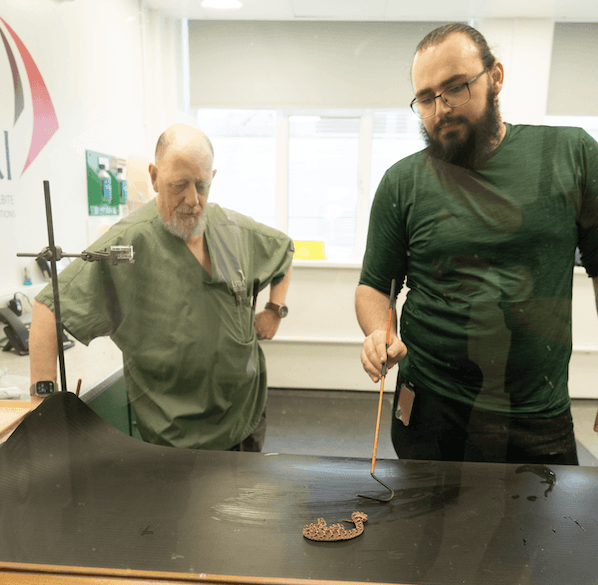 Die Schlangenpfleger Edouard Crittenden (rechts) und Paul Rowley mit einer giftigen Sandrasselotter im Labor.