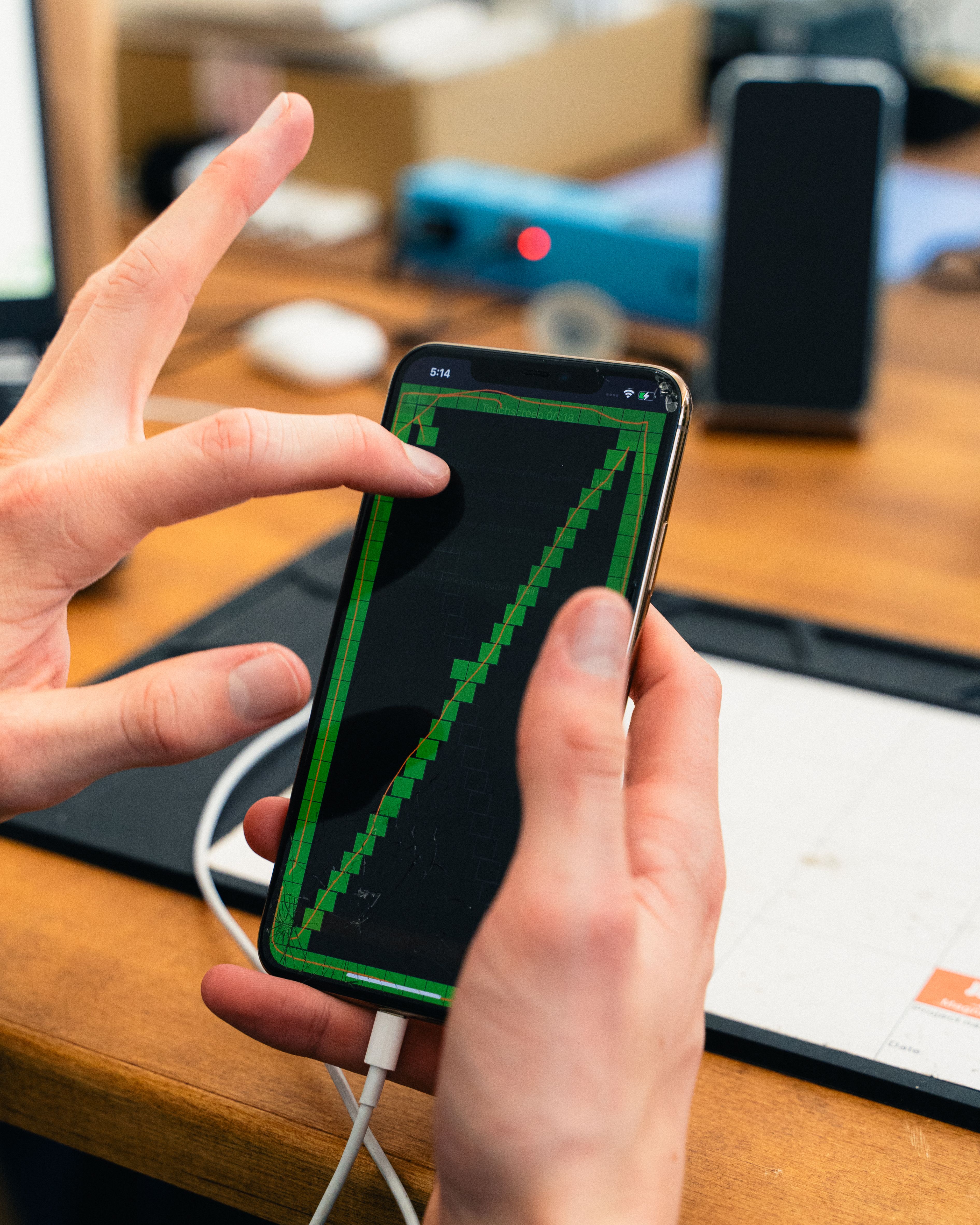 Ein Mitarbeiter von Mobileup prüft die Funktionalität des Bildschirms eines Handys aus zweiter Hand