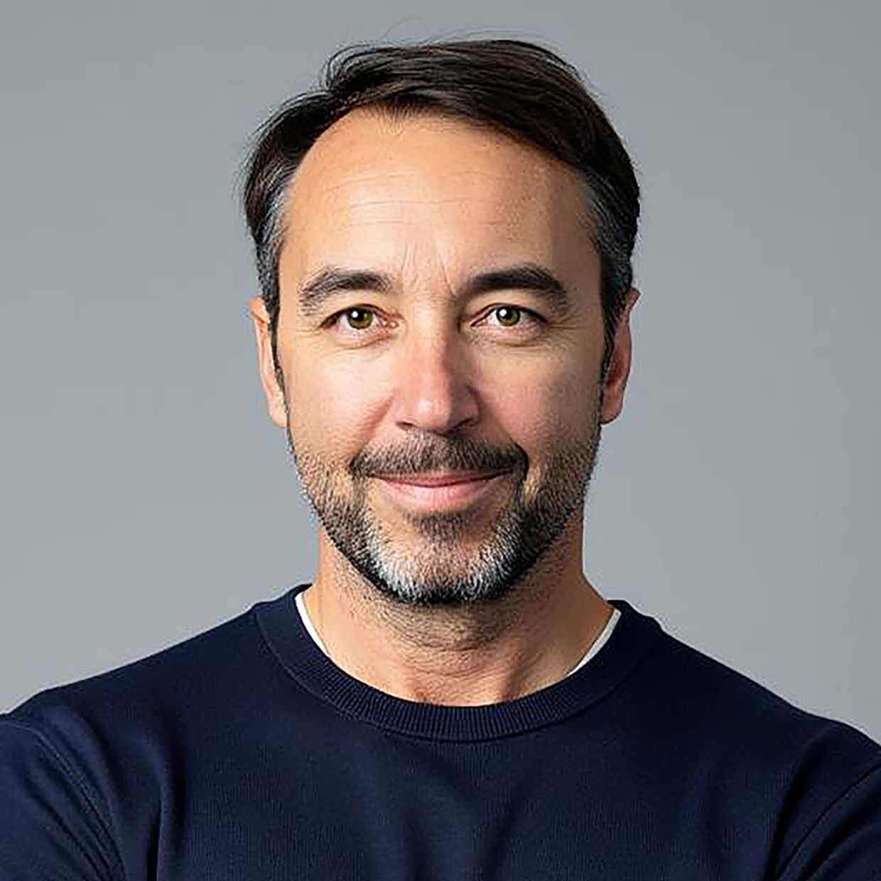 Oliver Brunschwiler in top scuro davanti a uno sfondo grigio in un ritratto