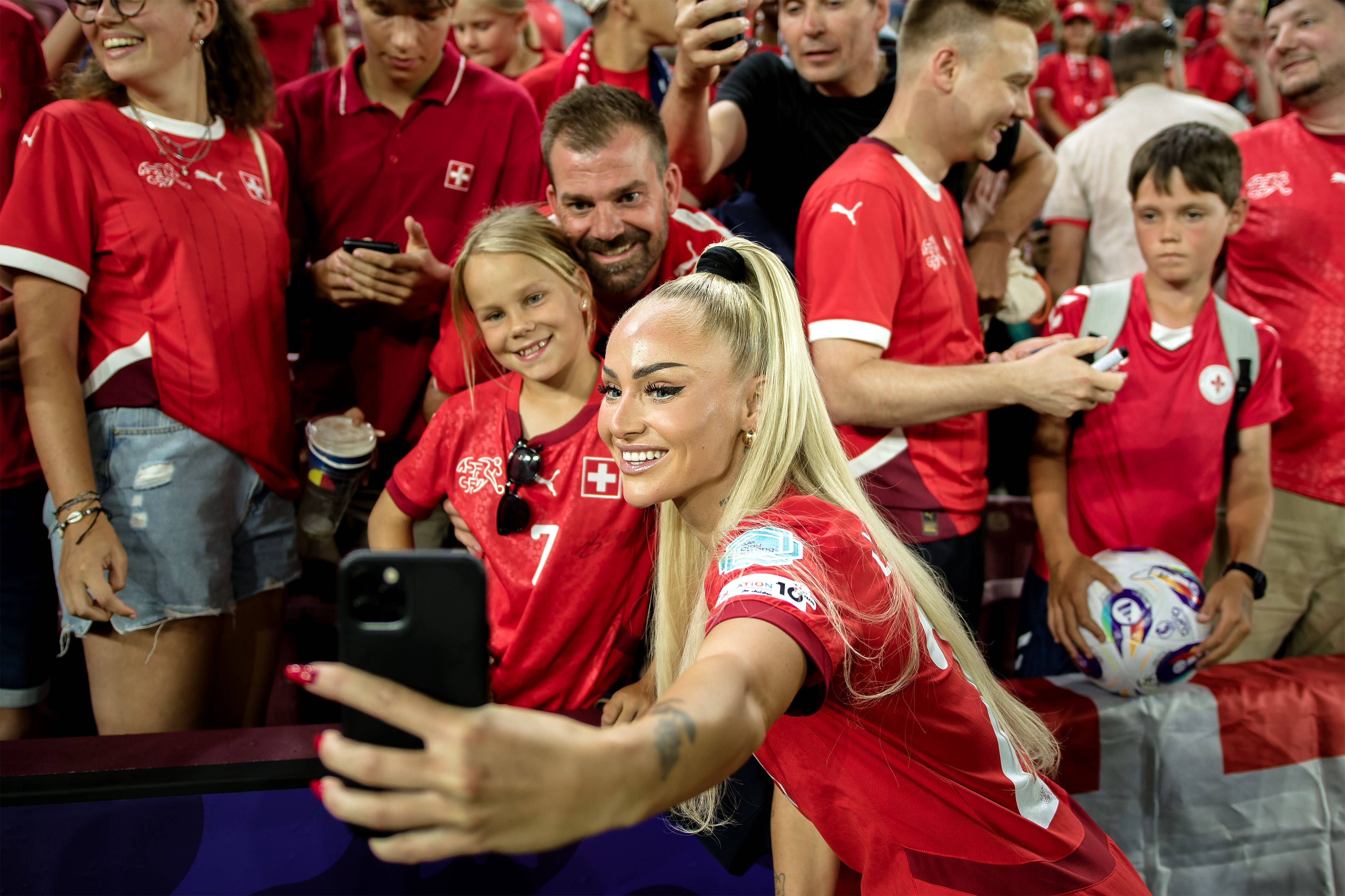 La joueuse de football suisse Alisha Lehmann prend des selfies avec des fans après le match