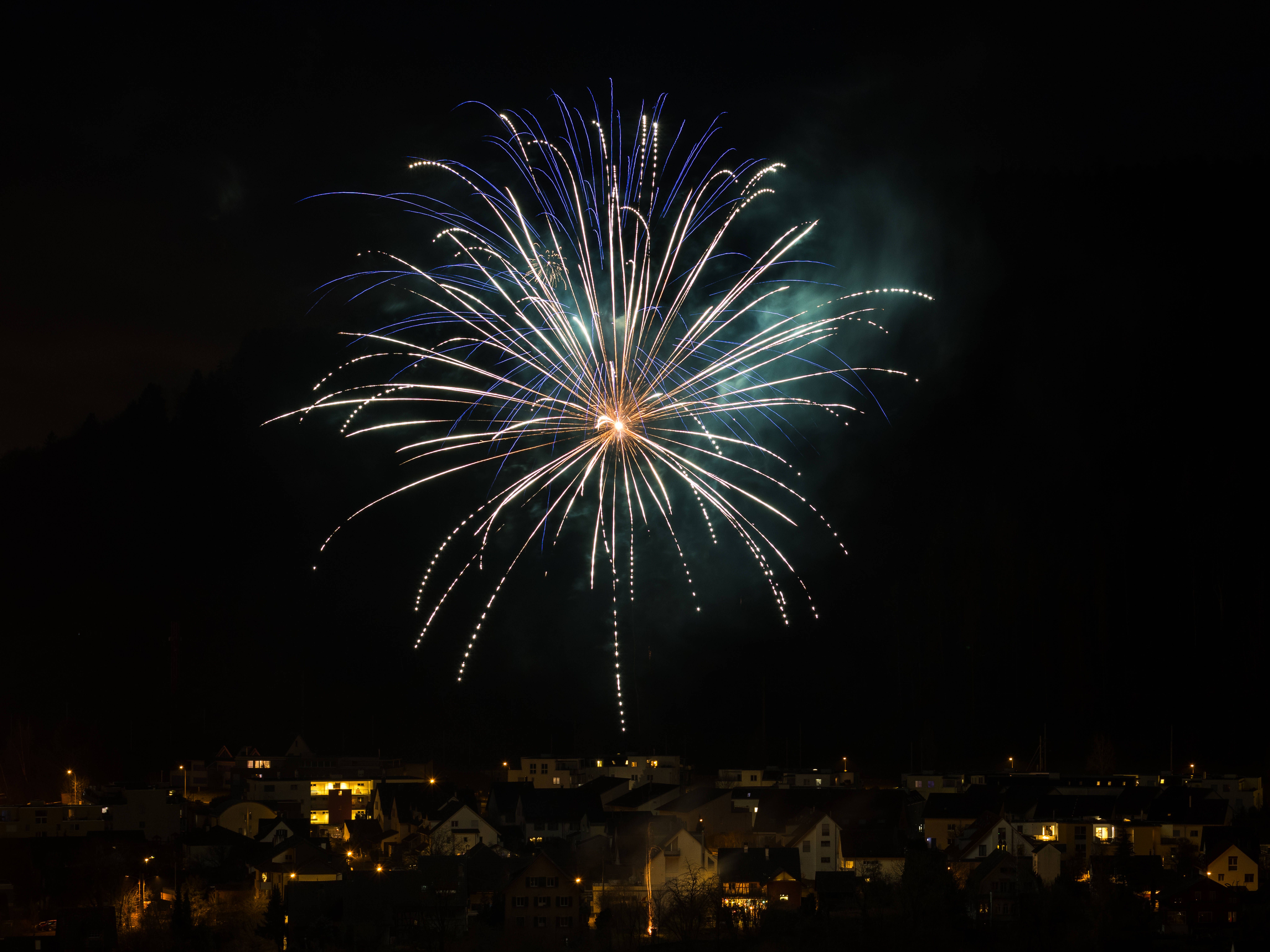 Ein Feuerwerk am Nachthimmel über einem Dorf 