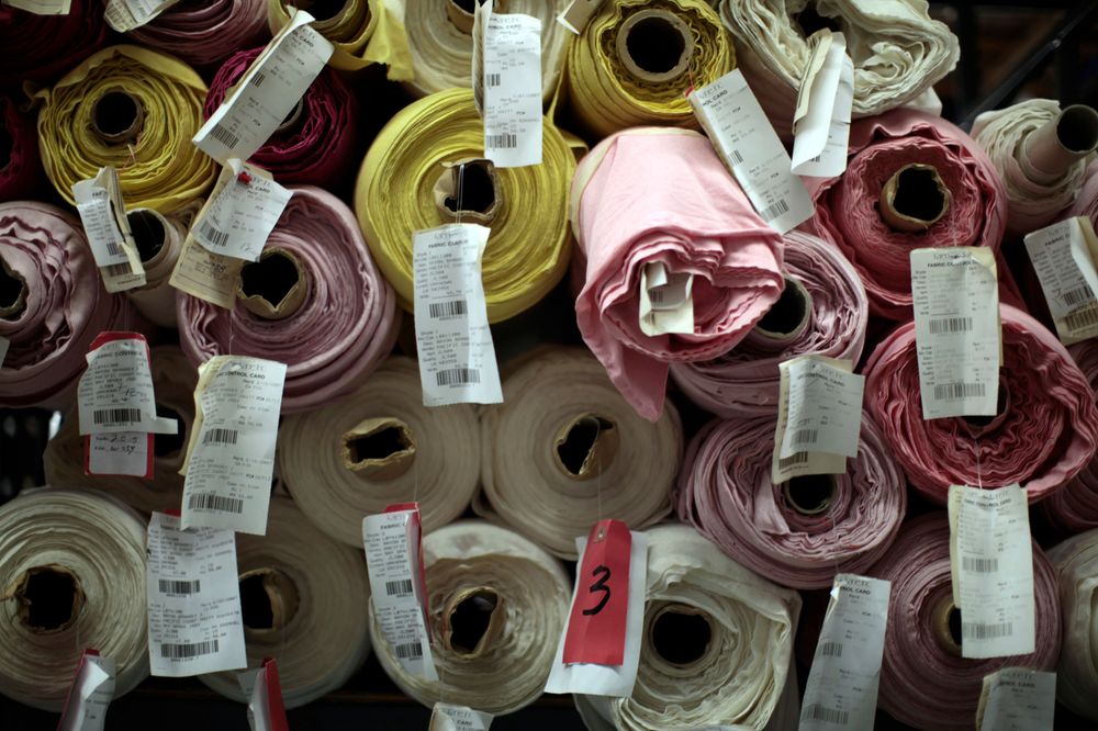 Stoffrollen türmen sich in einem Geschäft übereinander auf