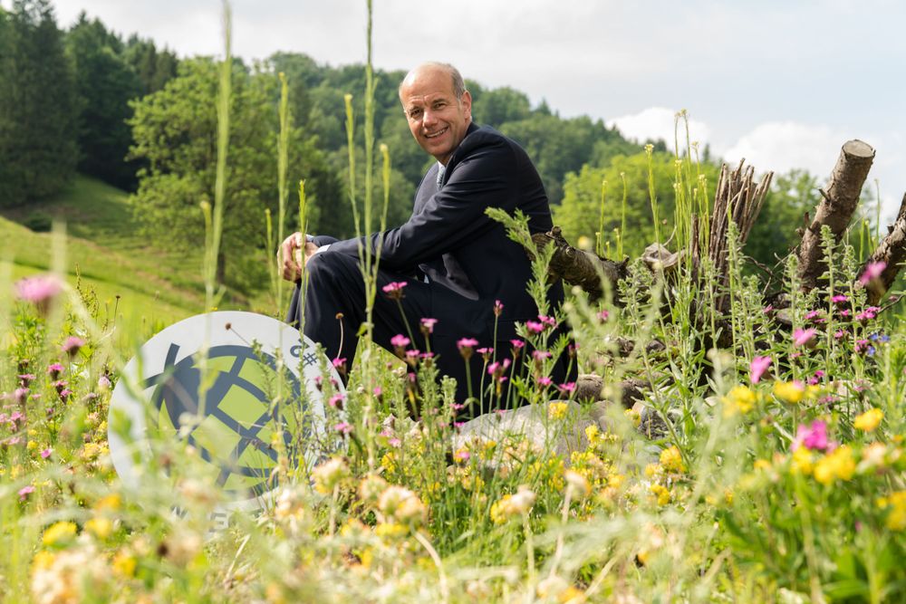 Hans-Dietrich Reckhaus in abito blu scuro su un prato con il logo Insect-Respect