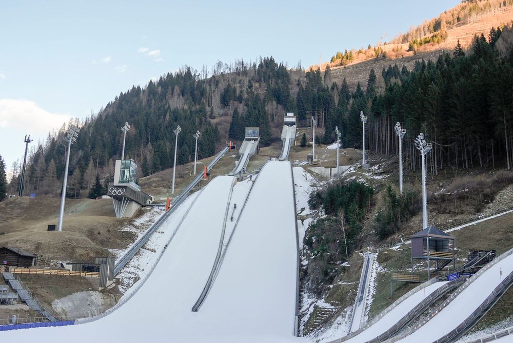 Ohne Kunstschnee geht es nicht mehr: Die Skisprung- und Nordisch-Anlage in Predazzo vor den olympischen Winterspielen. 