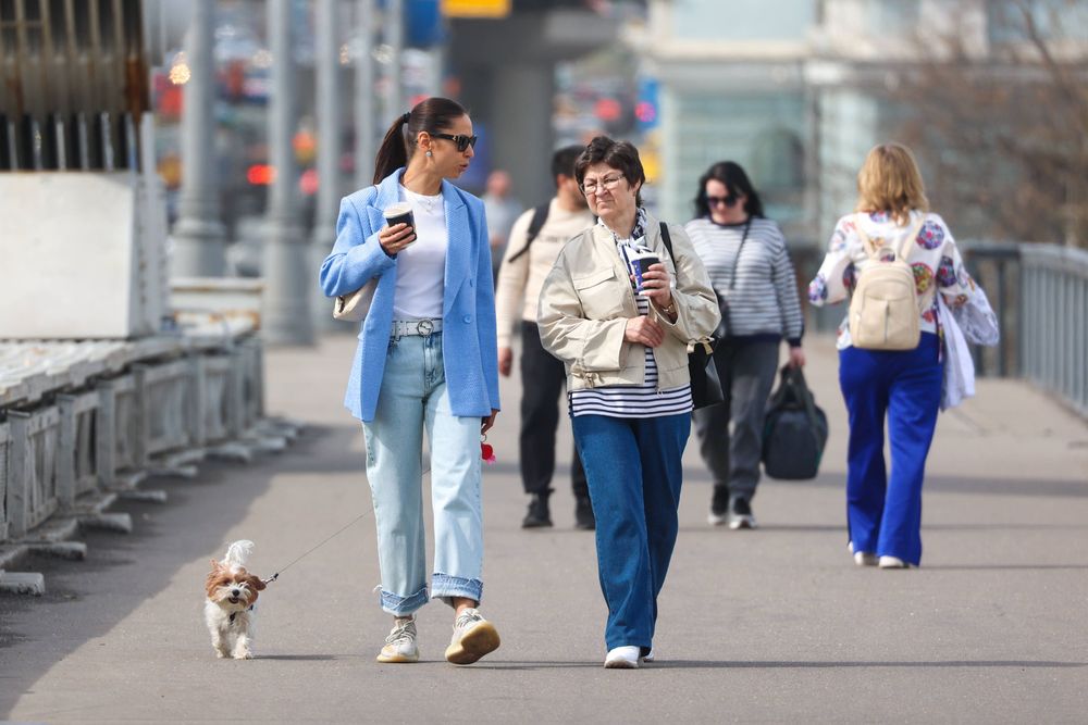 Zwei Frauen spazieren mit einem Hund