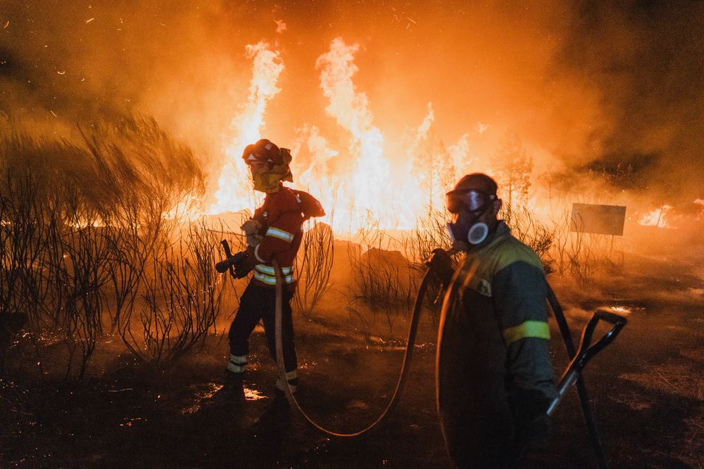 Feuerwehrleute und lokale Waldbrigaden kämpfen in der Nacht gegen einen Waldbrand im galicischen Ourense, der Wohngebiete bedroht.
