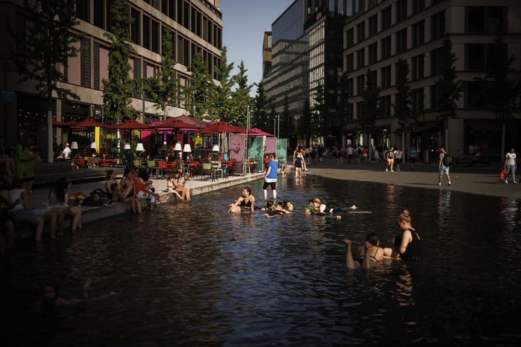Menschen kühlen sich im Wasserspiel in der Europaallee in Zürich ab