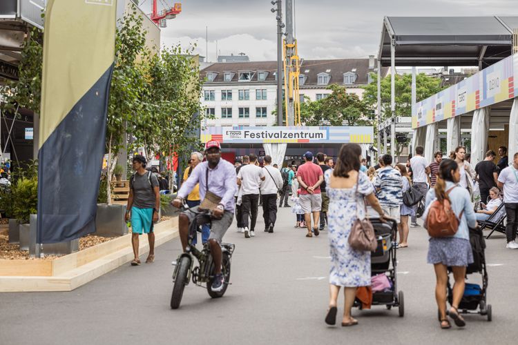 Menschen gehe über das Gelände der E-nova 2023 in der Zürcher Europaallee