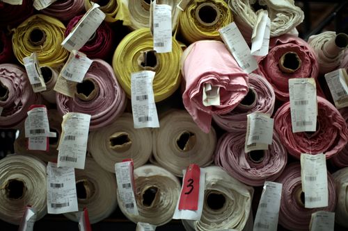 Stoffrollen türmen sich in einem Geschäft übereinander auf