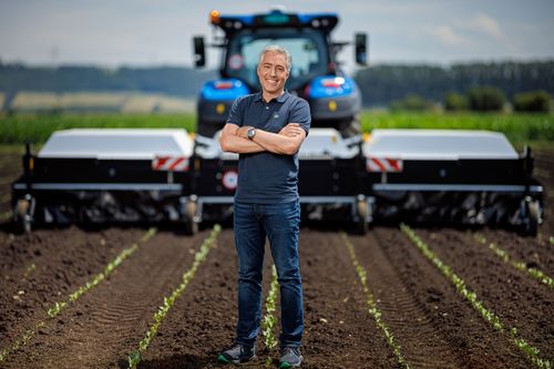 Aurélien Demaurex auf einem Feld vor einem Traktor mit der von ihm mitentwickelten Feldspritze ARA