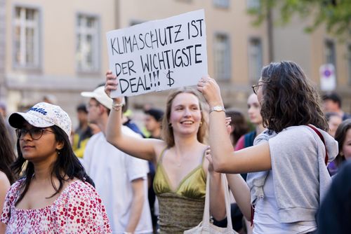 Zwei junge Frauen halten ein Plakat hoch an einem Klimastreik in der Schweiz